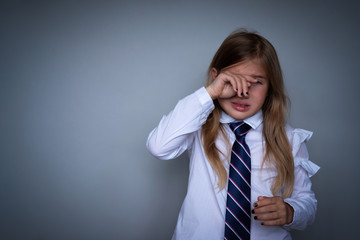 Small schoolgirl covering face, crying portrait. Preteen stressed, scared child hiding, wiping off...