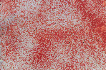Beautiful horizontal texture of part of old concrete wall painted in white and spray red color with holes on the photo