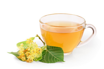 Tea from Linden flowers in glass cup with flower clusters of lime isolated on white background