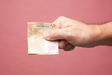 Acción de tener dinero en la mano, billetes de Euro. Acción de entregar dinero por la compra de...