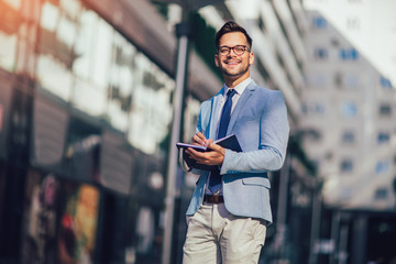 Portrait of a young happy businessman outside the office building
