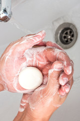 The hands of a man who washes his hands with soap dispenser.