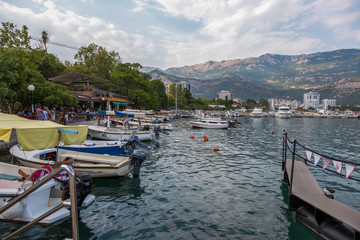 Fototapeta na wymiar Jetty of boats and yachts on the embankment of Budva