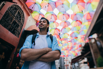 A man tourist walks through the streets with a backpack