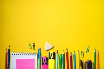 School supplies on yellow background. Top view. Copy space.