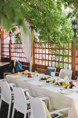 Wedding table setting. Festive table with white tablecloth. guests sit at the table. on the table are fruits, cheeses, glasses. cheese and wine tasting