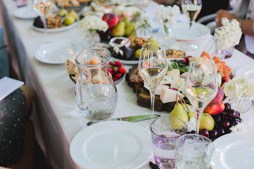Beautifully decorated catering banquet table with different food snacks and appetizers with sandwich, caviar, fresh fruits on corporate party event or wedding celebration