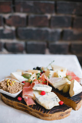Mix cheese on wooden board with grapes. Top view.
