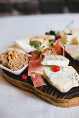 Mix cheese on wooden board with grapes. Top view.