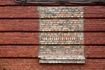 Red brick wall. The window is covered with bricks in the old house.