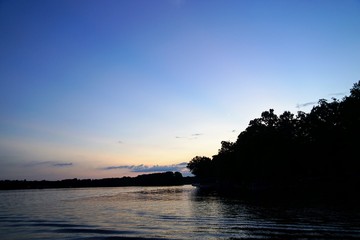 Naklejka na ściany i meble Sunset Over a Lake with Trees