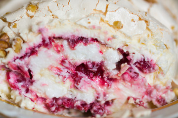 Meringue roll with fresh berries and walnuts in cross-section