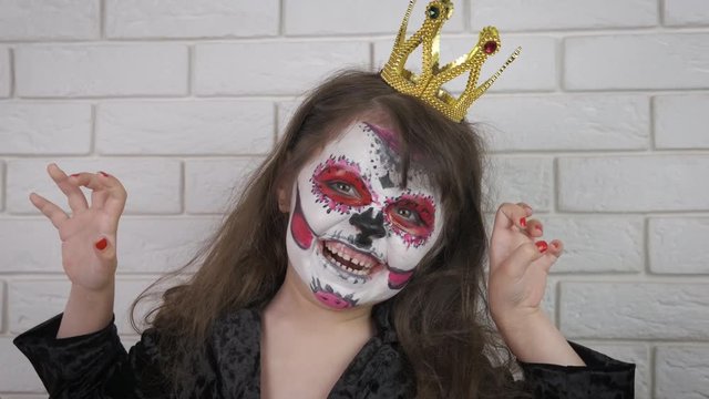 Makeup for Halloween. Little girl in scary makeup and crown for halloween. Halloween child.