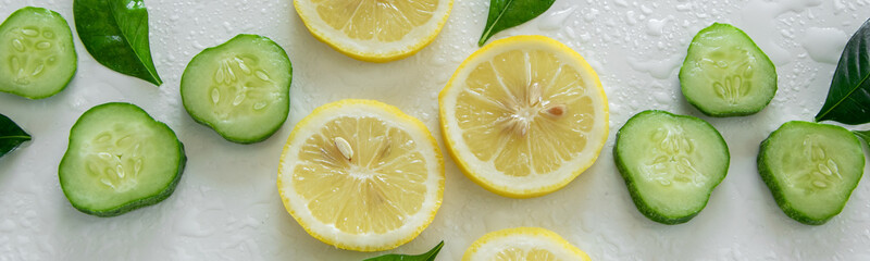 Fresh frutti background. Raw lemon and cucumber slices on white background