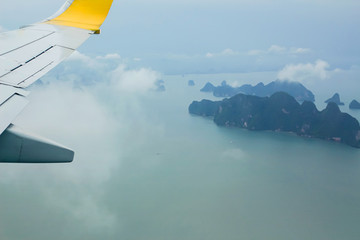 Naklejka na ściany i meble High angle view on plane Thailand At daytime,view from the plane window mountains and sea near Phuket Island.