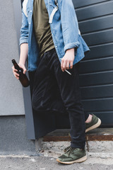 cropped view of boy smoking cigarette and drinking beer