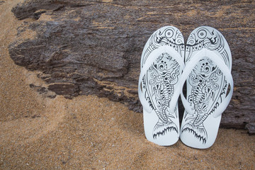 Beautiful white sandals on a wooden stick a tropical beach in Phuket, Thailand.