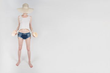 the girl in shorts and hat covering her face staying and holding the clamshells on white background isolated