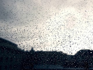 An amazing photography of some waterdrops over the window after summer rain in the city