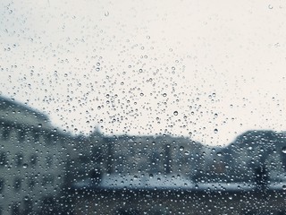 An amazing photography of some waterdrops over the window after summer rain in the city