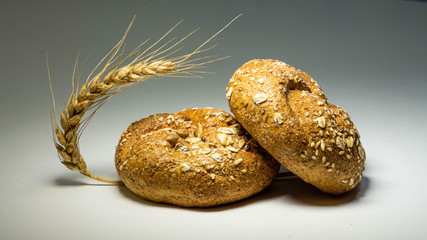 Freshly baked tasty two loafs of bread with a spikelet of wheat, close-up.