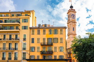 Fototapeta premium Nice, France, colorful facade, with typical windows and shutters, and the Saint-Francois bell in background 