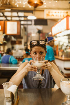 young surprised lady with short hair drinks horchata in mexico
