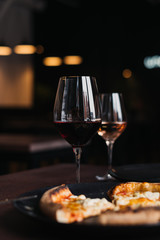 Still life shot of glasses with wine and pizza