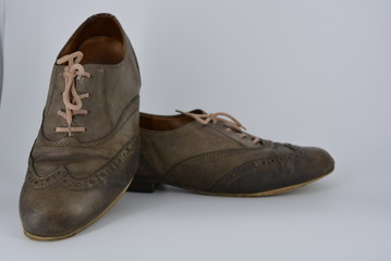 Women's unusual gray brown shoes, shoes from genuine leather in the English style. Aristocratic and antique shoes with worn leather and special colors are located on a white background.