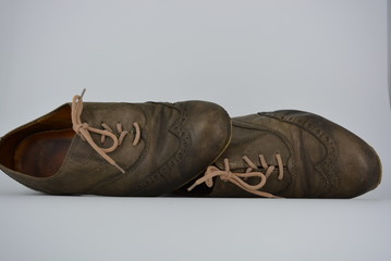 Women's unusual gray brown shoes, shoes from genuine leather in the English style. Aristocratic and antique shoes with worn leather and special colors are located on a white background.