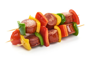 Skewers with pieces of grilled sausage and vegetables BBQ, close-up, isolated on white background