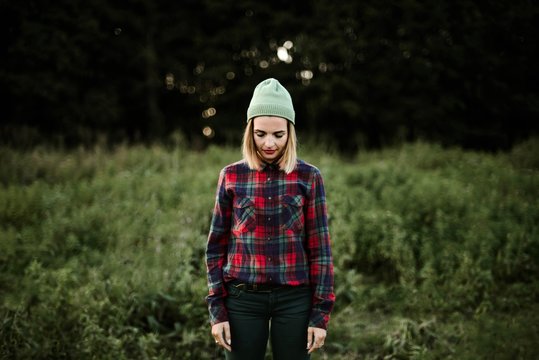 Young beautiful hipster woman standing on field in the countryside