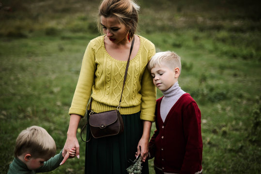 Two children playing with their mother on a beautiful autumn day