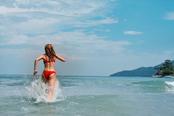 beautiful young woman running in the sea.