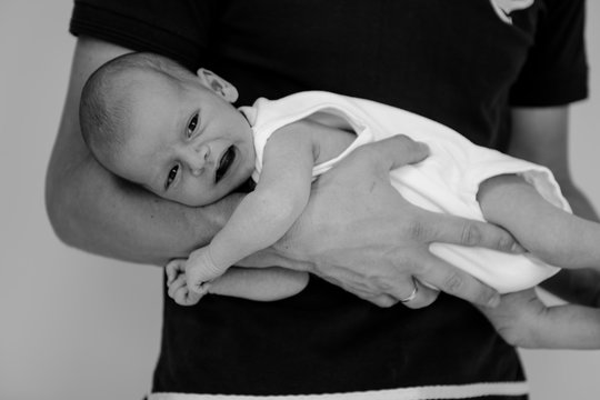 emotional newborn kid in parent hands