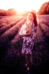 Eine junge wunderschöne Frau steht im romantischem Lavendelfeld