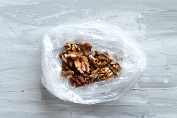 Fresh walnut packed into the plastic bag, food flat lay with space for text, ecological concept