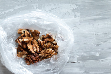 Fresh walnut packed into the plastic bag, food flat lay with space for text, ecological concept