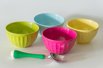 Colorful ice cream bowls and ice cream scoop with a white background