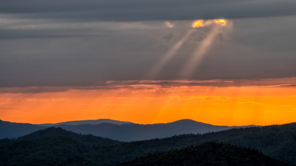 A wonderful sunset in the mountains. Orange sky and dark silhouettes of mountains. Carpathian Mountains landscape. Bieszczady. Poland