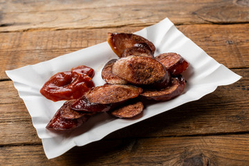 fried sliced sausage -  dish on a paper tray
