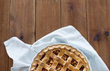 food, culinary and baking concept - close up of apple pie in mold on wooden table