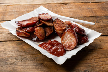 fried sliced sausage -  dish on a paper tray