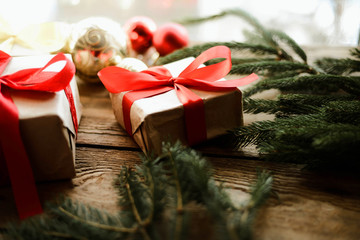 Christmas presents in red ribbon on a wooden background