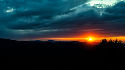 Fototapeta premium A wonderful sunset in the mountains. Orange sky and dark silhouettes of mountains. Carpathian Mountains landscape. Bieszczady. Poland
