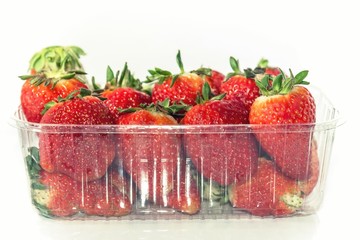 Package of strawberries on a white background, close up, isolated.