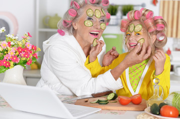 Portrait of senior woman and granddaughter at kitchen