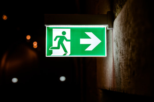Emergency exit sign illuminated with dark background.