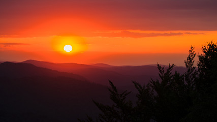 A wonderful sunset in the mountains. Orange sky and dark silhouettes of mountains. Carpathian Mountains landscape. Bieszczady. Poland