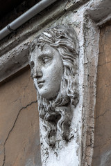 female head on the facade of an old house. Mascaron on an old Art Nouveau building in St. Petersburg, Russia